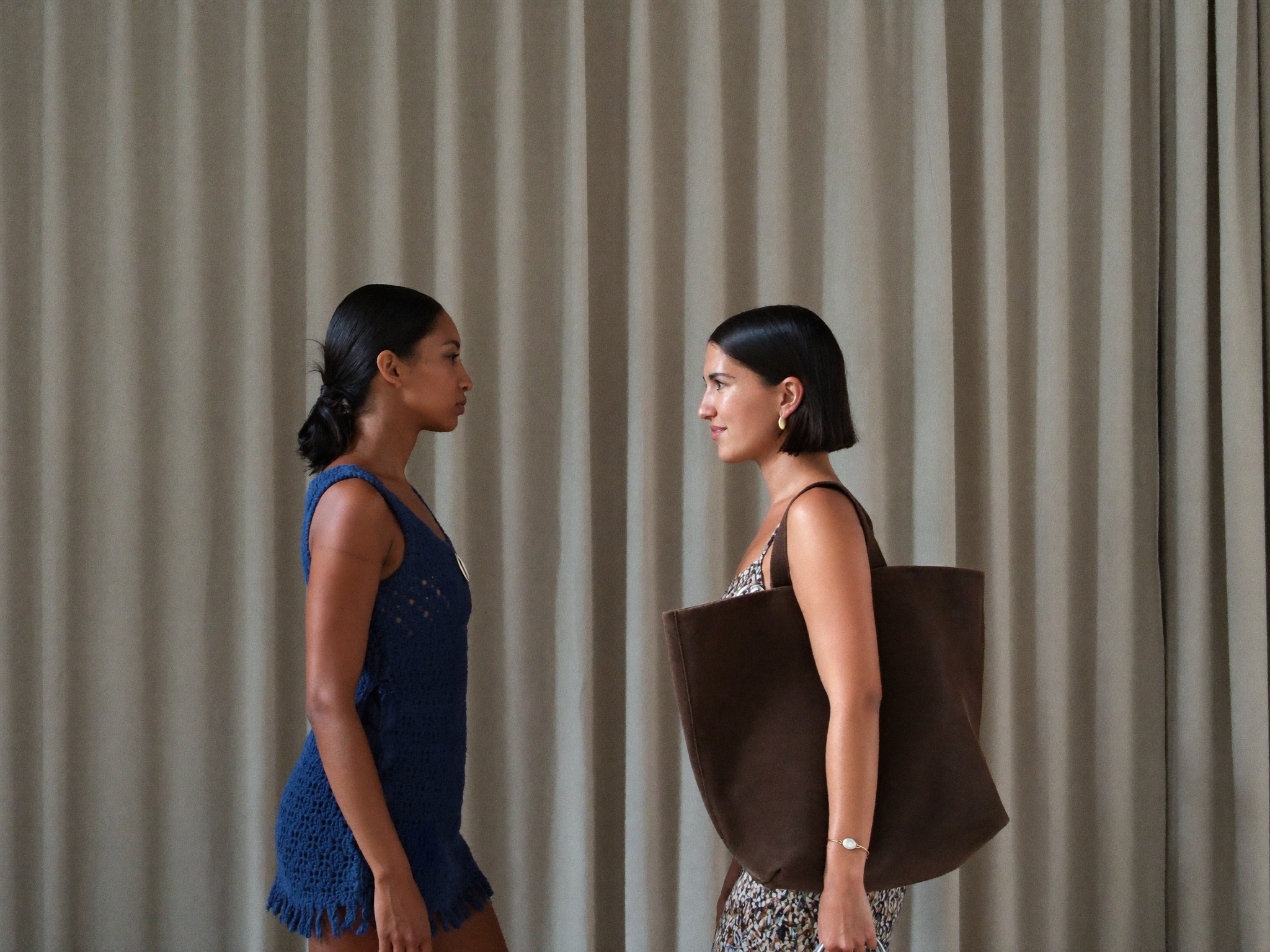 A woman wearing a large structured tote on her shoulder